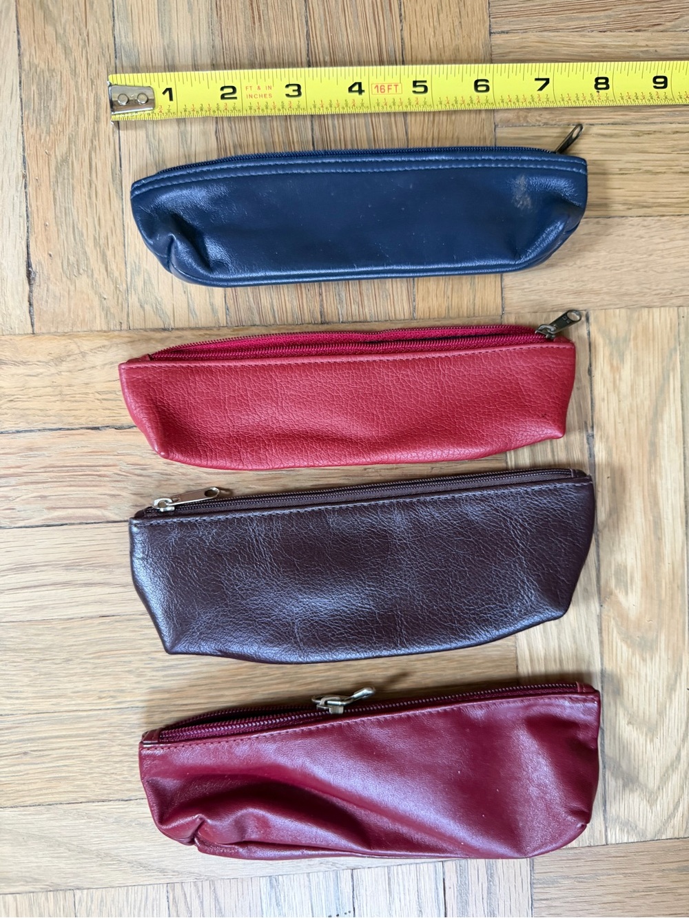 Vintage leather pencil cases in navy, red, burgundy, and maroon.